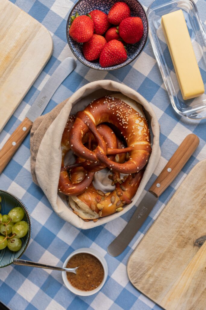 Bayrischer Frühstücktisch mit Brezn, Butter und Erbeeren.