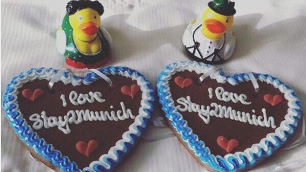 2 Badeenten in Trachten vor Lebkuchenherzen mit der Aufschrift